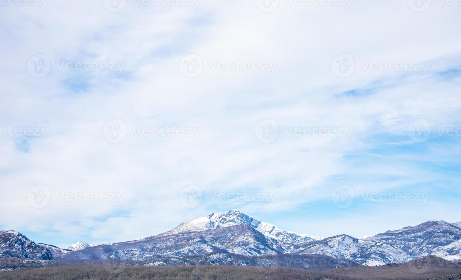 snow capped mountains with blue sky and clouds photo