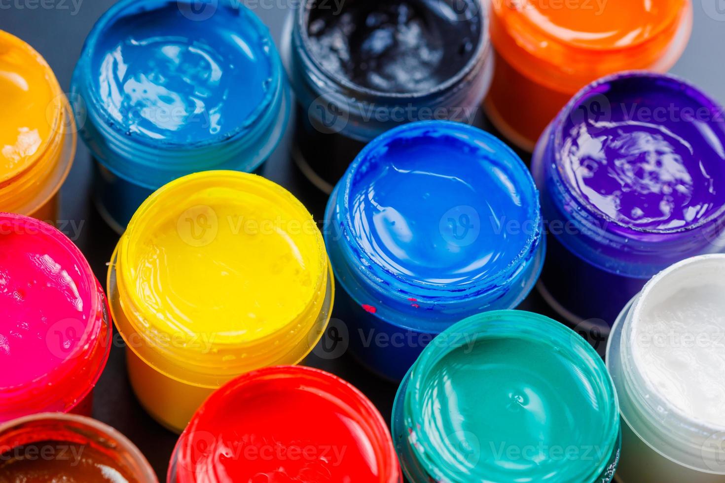 full-frame close-up background of opened small gouache paint jars photo