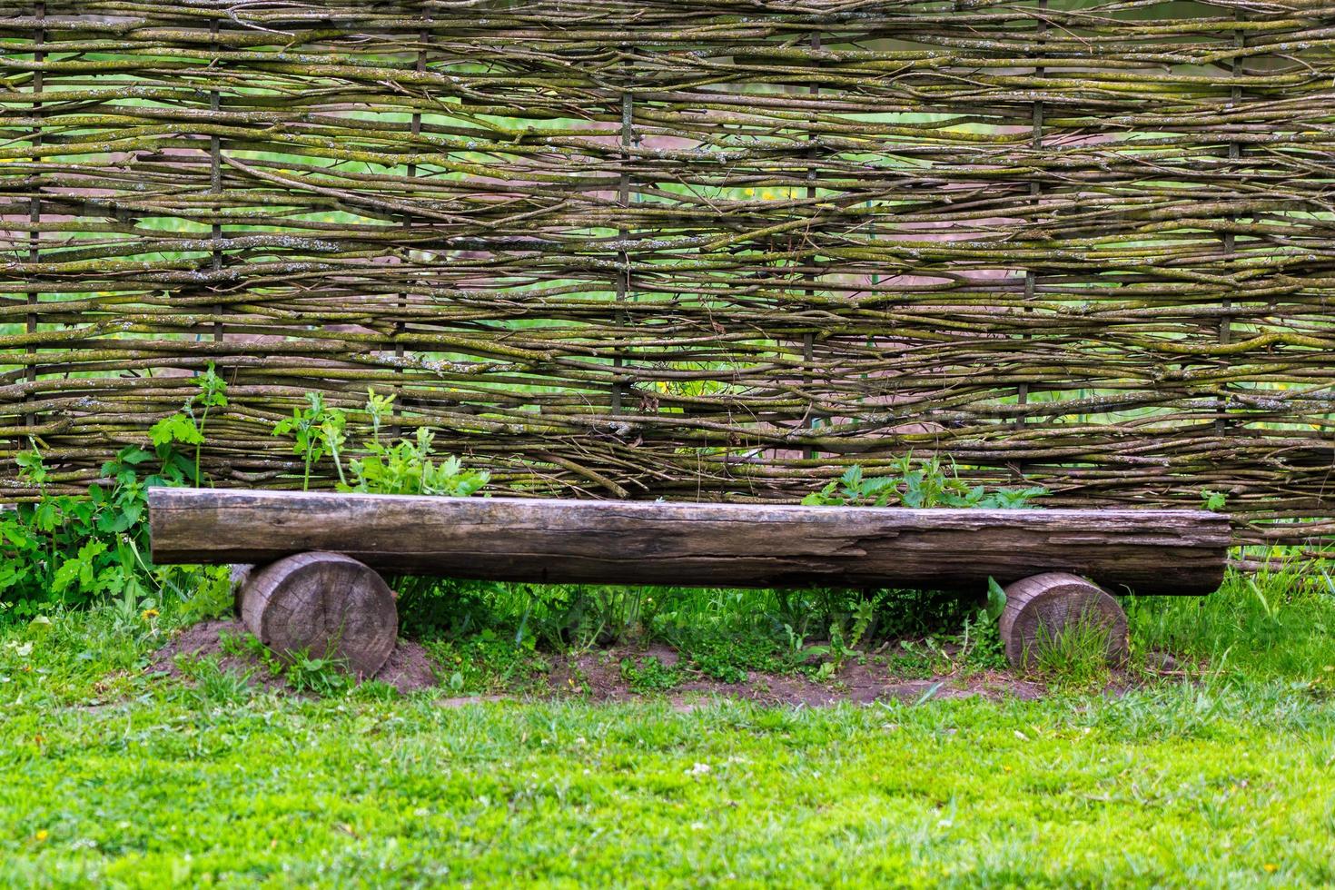 horizontal wattle fence with wooden bench near photo