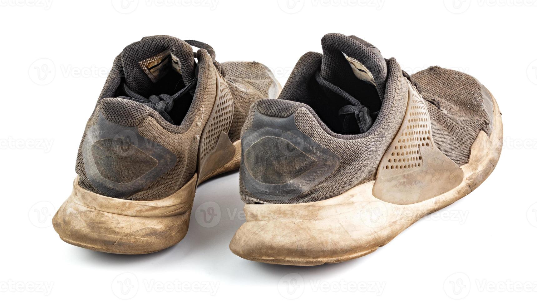 a pair of weared dirty sneakers isolated on white background photo