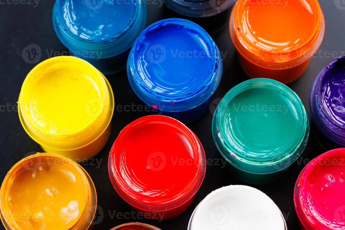 full-frame close-up background of opened small gouache paint jars photo