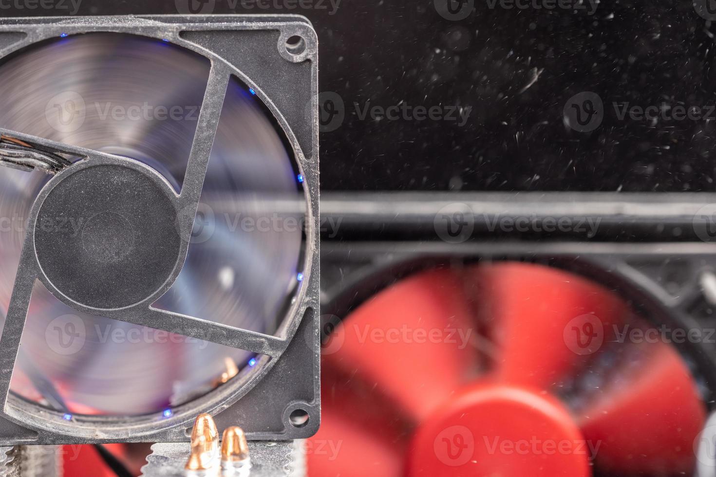 spinning 90 mm pc fan close-up with thick layer of dust and flying airborne dust particles photo