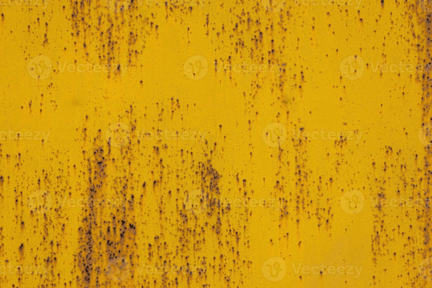 full frame background and texture of yellow painted sheet steel with multiple rust spots on it photo