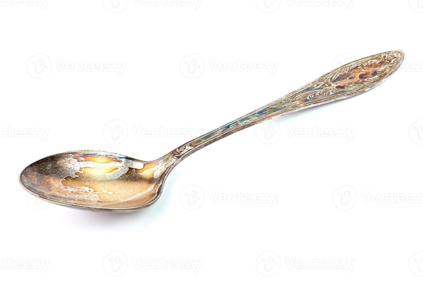 German silver or cupronickel spoon with visible oxidation layer isolated on white baclground photo