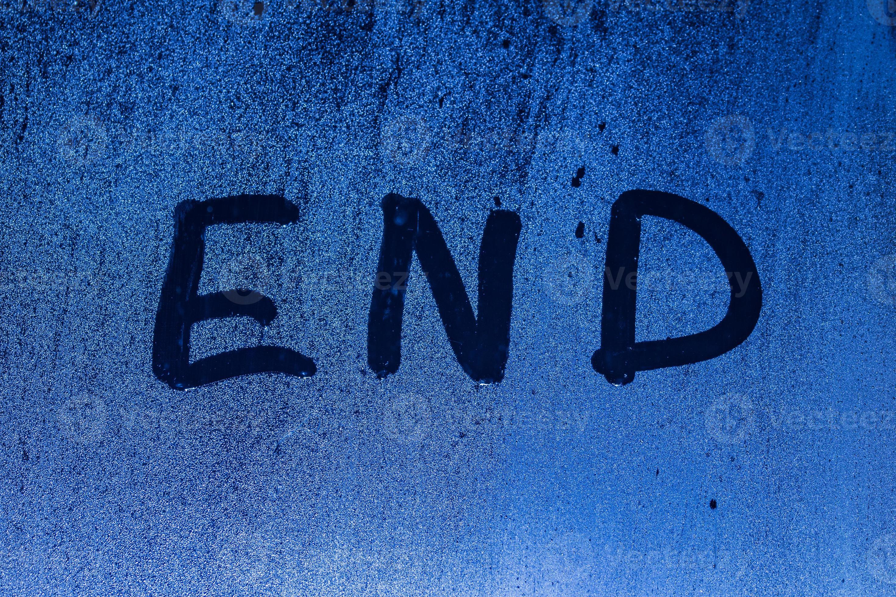 The word end written on night sweaty window glass with blurred blue