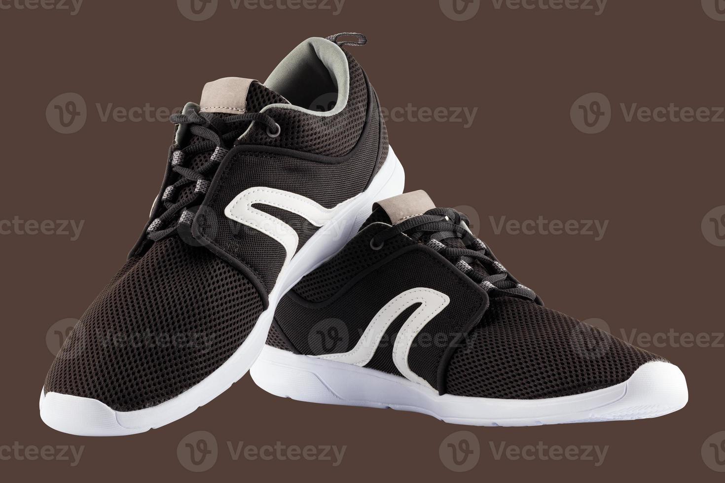pair of black airmesh summer walking lightweight shoes isolated on brown background photo