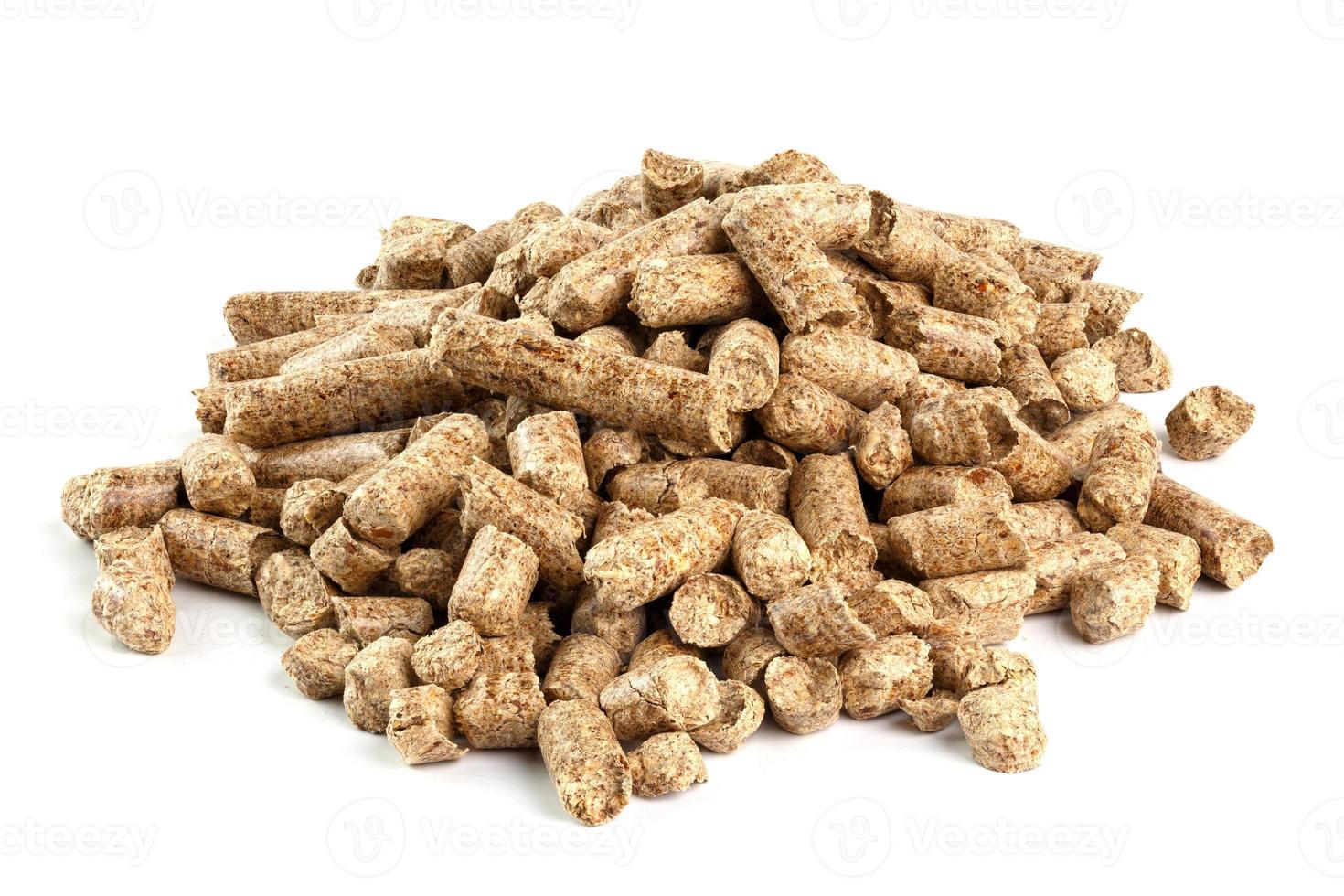 pequeño montón de pellets de aserrín de madera prensada aislado sobre fondo blanco. biocombustible y arena para mascotas, mantillo. foto