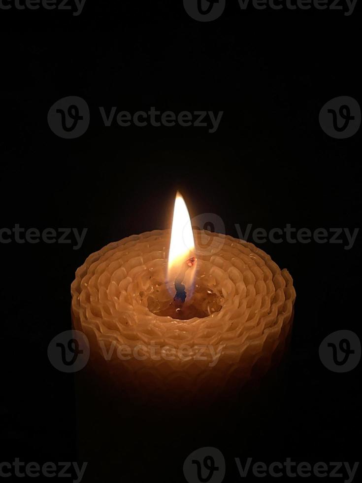 A wax candle burning in the dark photo