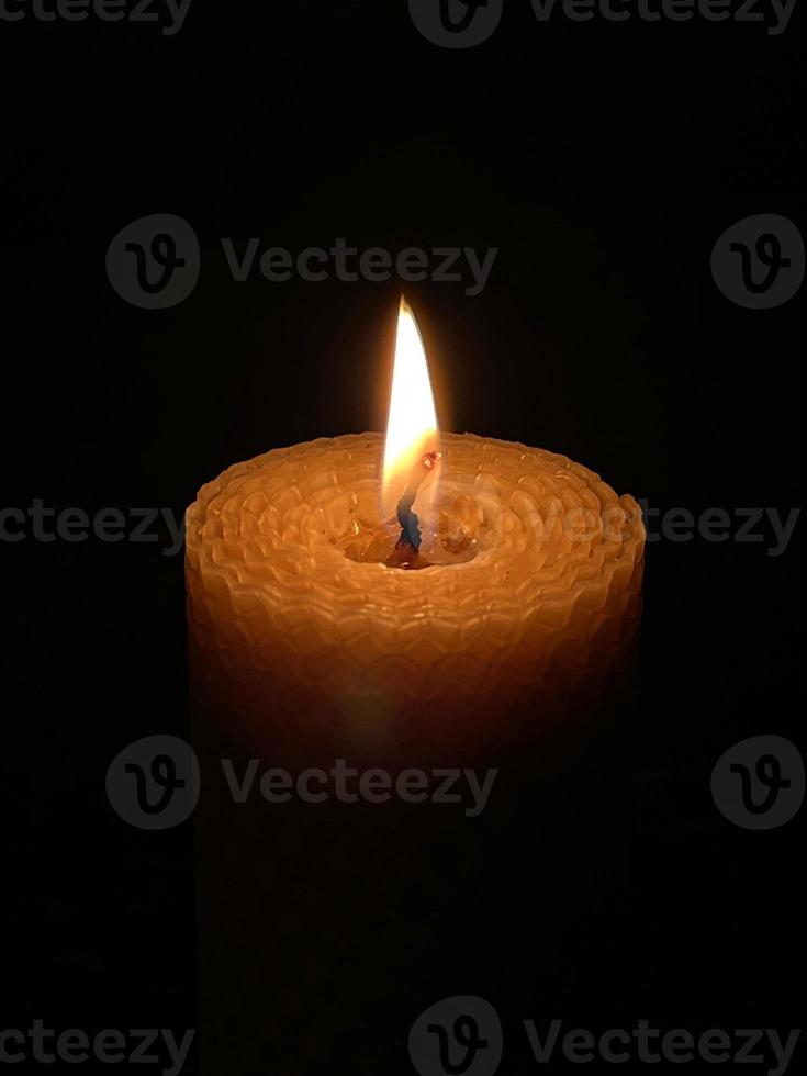 A wax candle burning in the dark photo