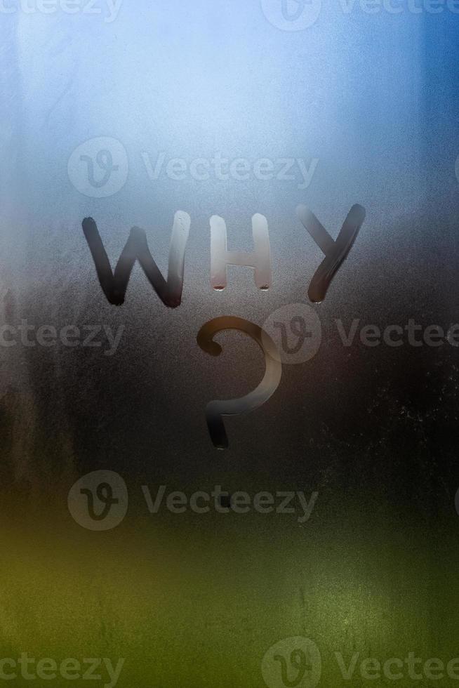 the question who written by finger on wet glass with blurred lights in background photo