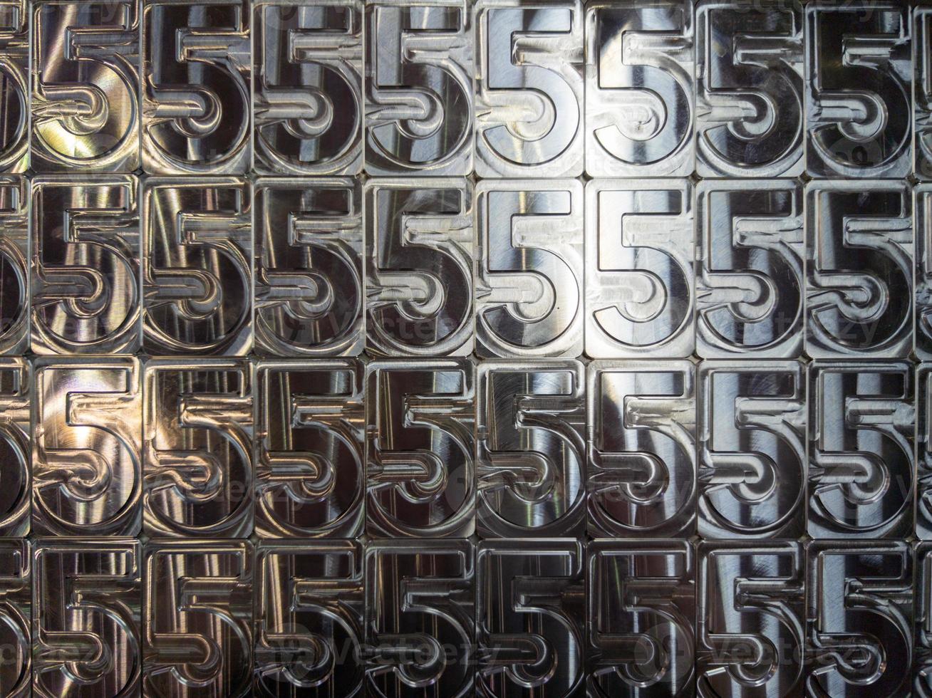 shiny metal machined digit 5 plates tiled tightly - full frame background photo