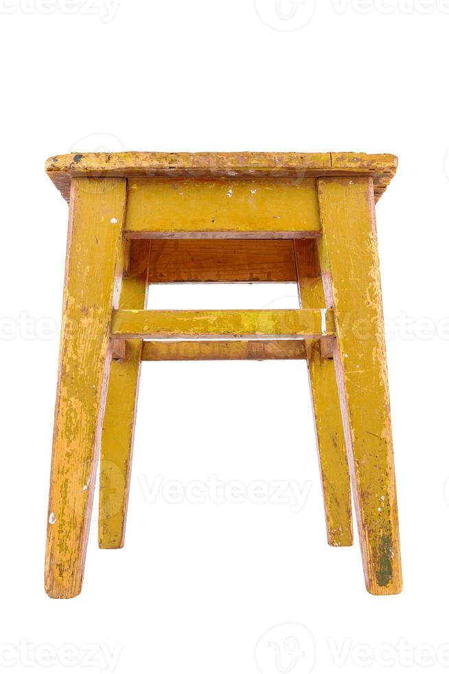 Old wooden stool with yellow peeling paint. Loft style chair isolated on a white background. photo