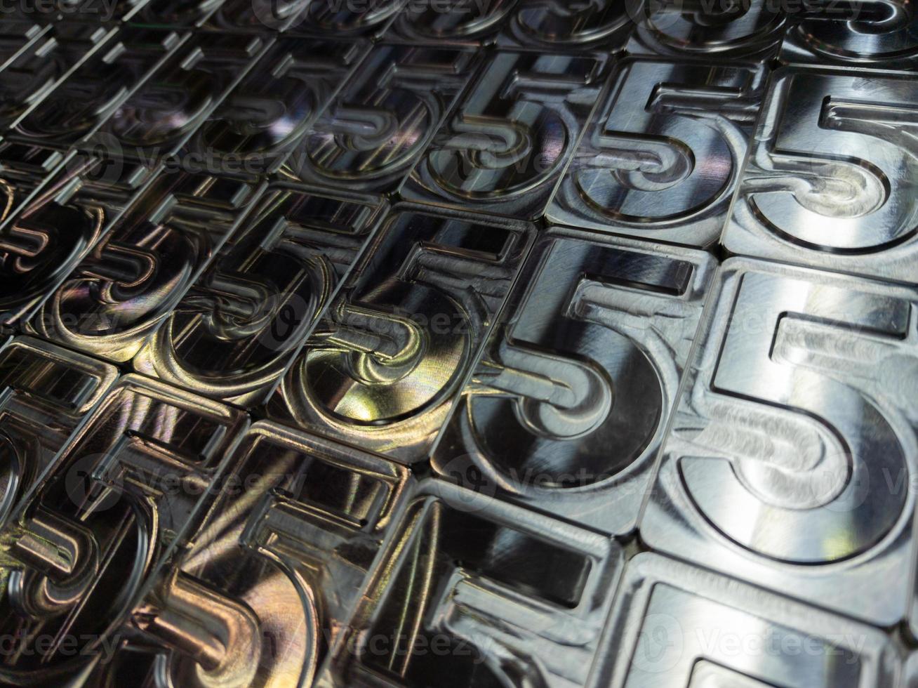 shiny metal machined digit 5 plates tiled tightly - full frame background photo