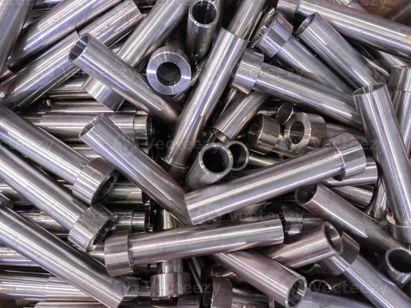 pile of shiny steel tubes after cnc turning operations - abstract full frame indistrial background photo