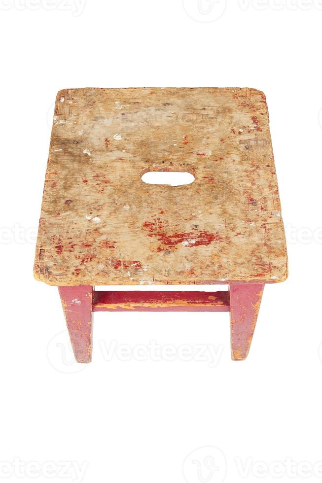 Old wooden stool with peeling red paint. Loft style chair isolated on a white background. photo