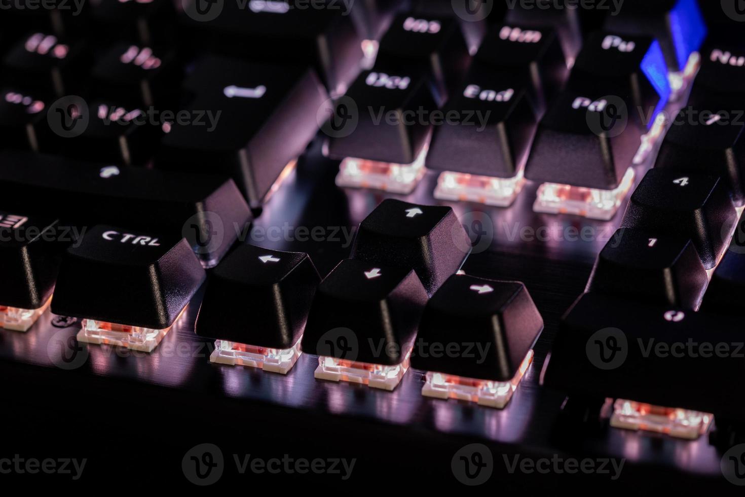 a close-up view of black mechanical pc keyboard with white backlight photo