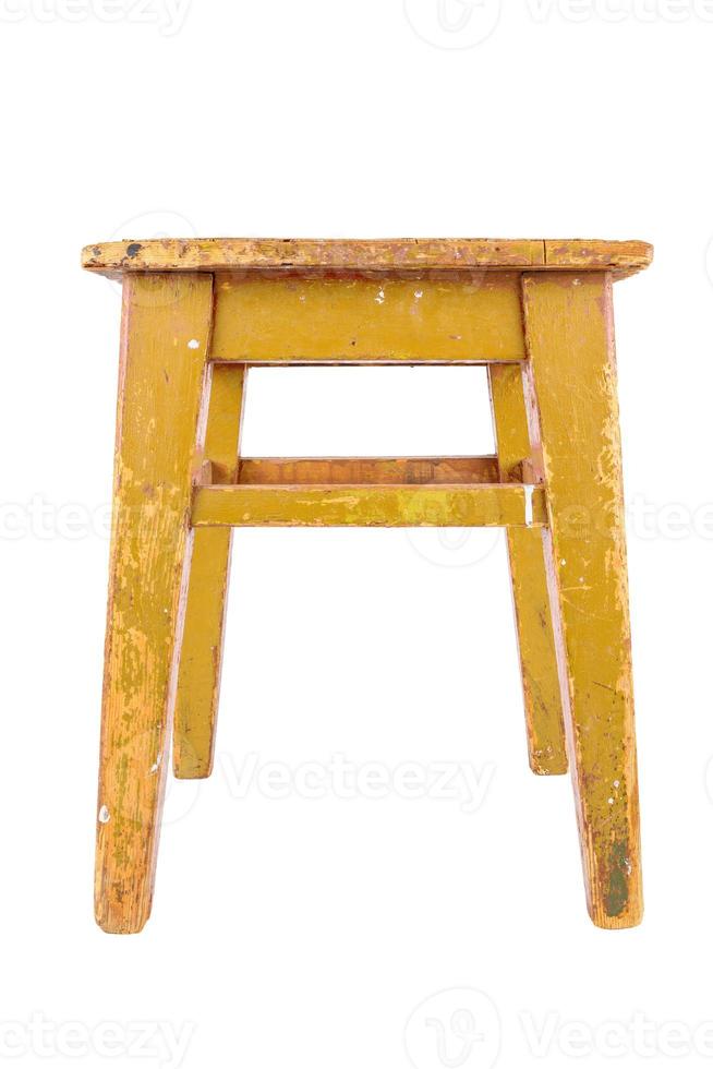 Old wooden stool with yellow peeling paint. Loft style chair isolated on a white background. photo