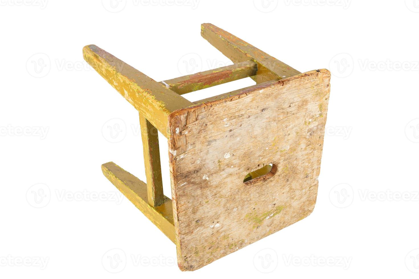Old wooden stool with peeling ocher yellow paint. Loft style chair isolated on a white background. photo