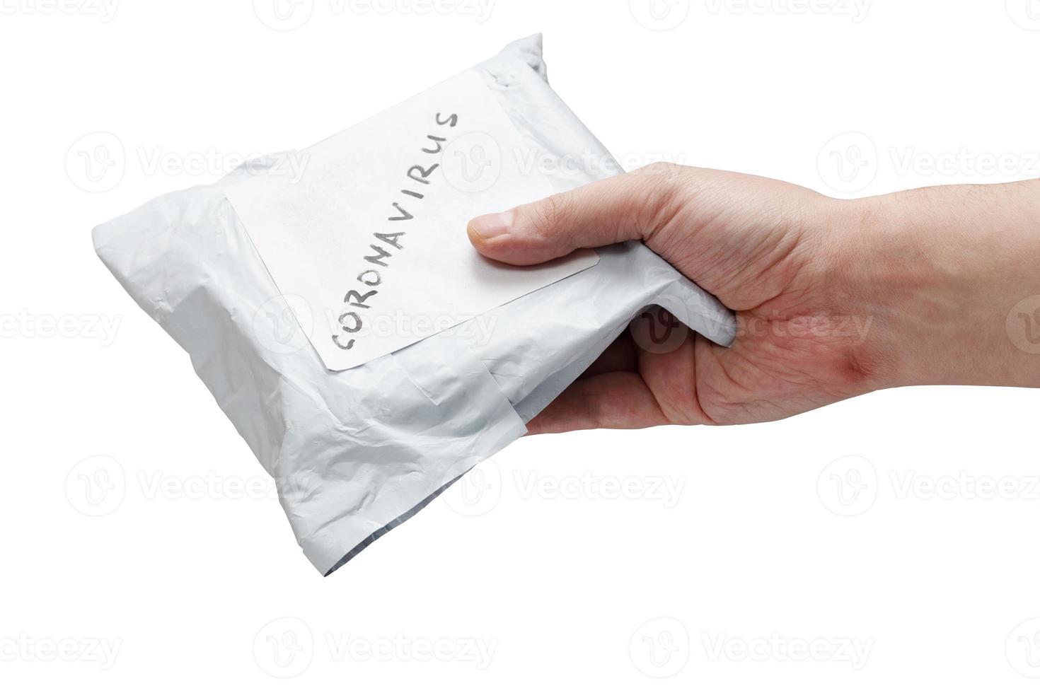 a hand giving small packet parcel from china with label coronavirus on it - isolated on white background photo