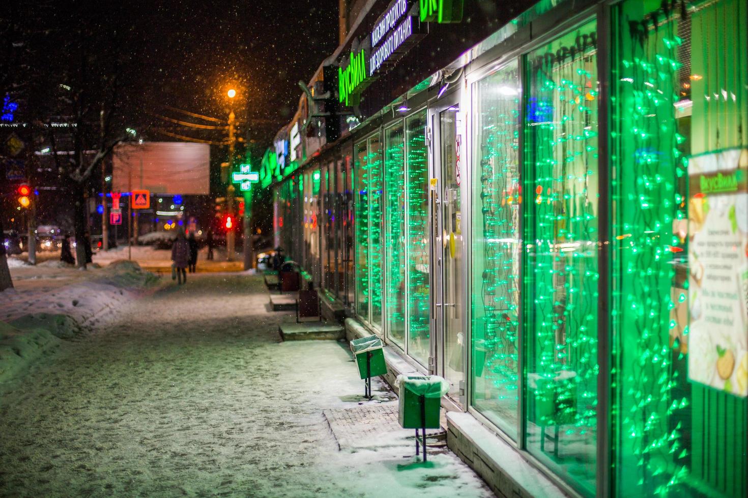 tula, rusia - 26 de diciembre de 2018, frente de la tienda en la calle de noche de invierno con luz led verde en chrismas. foto