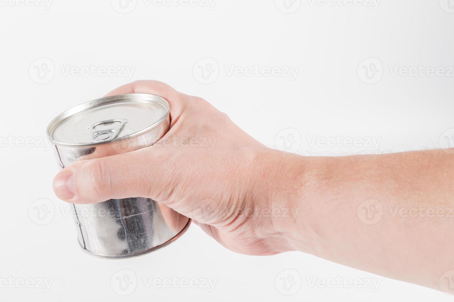bare caucasian hand holding a tin can with a pull ring on a white background photo
