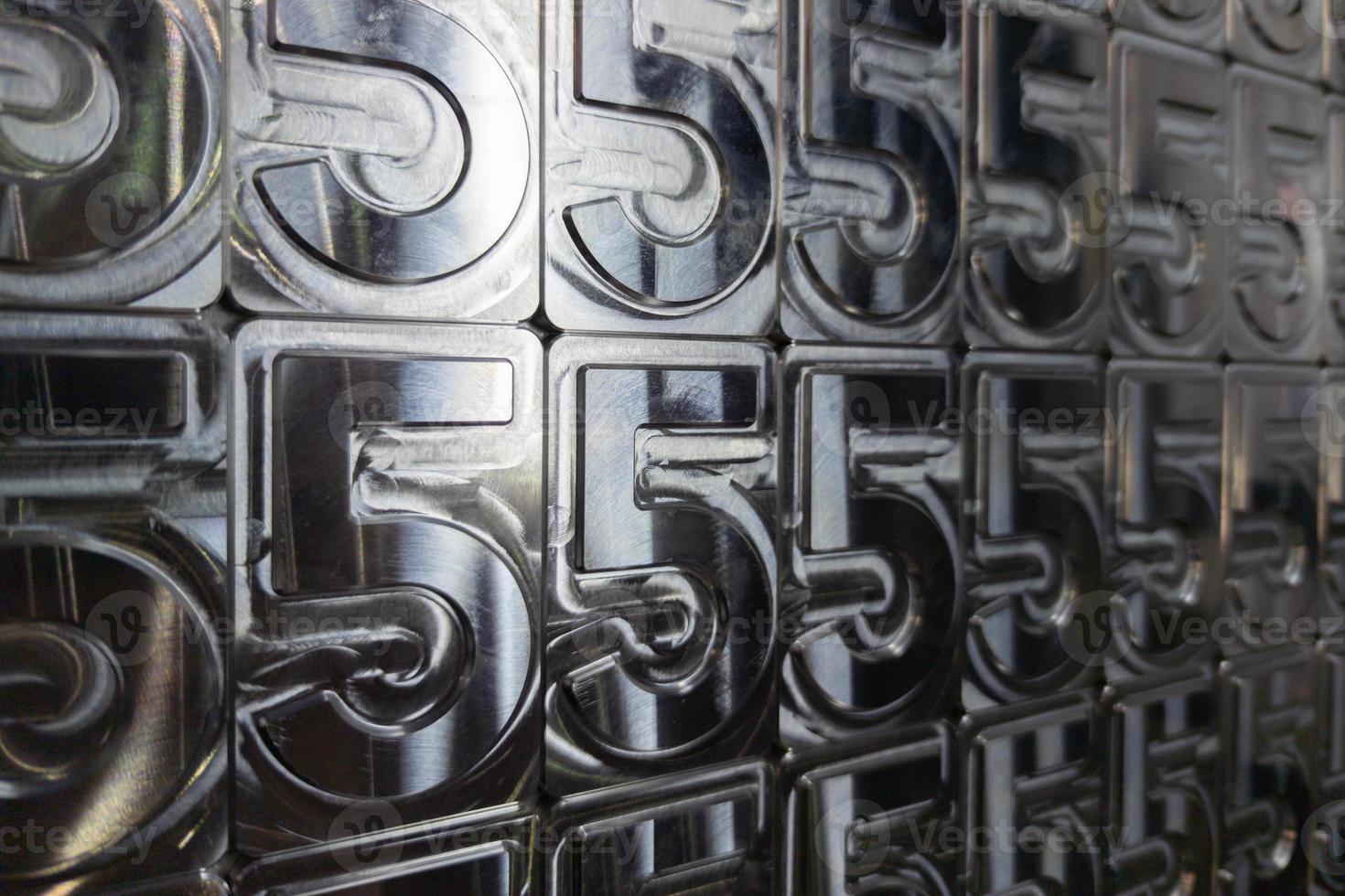 shiny metal machined digit 5 plates tiled tightly - full frame background photo