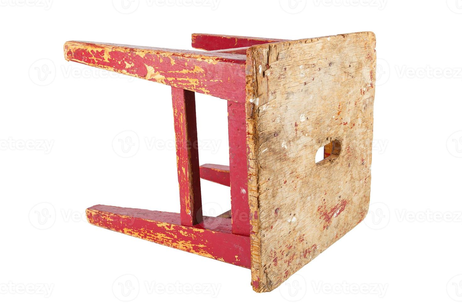 Old wooden stool with peeling red paint. Loft style chair isolated on a white background. photo