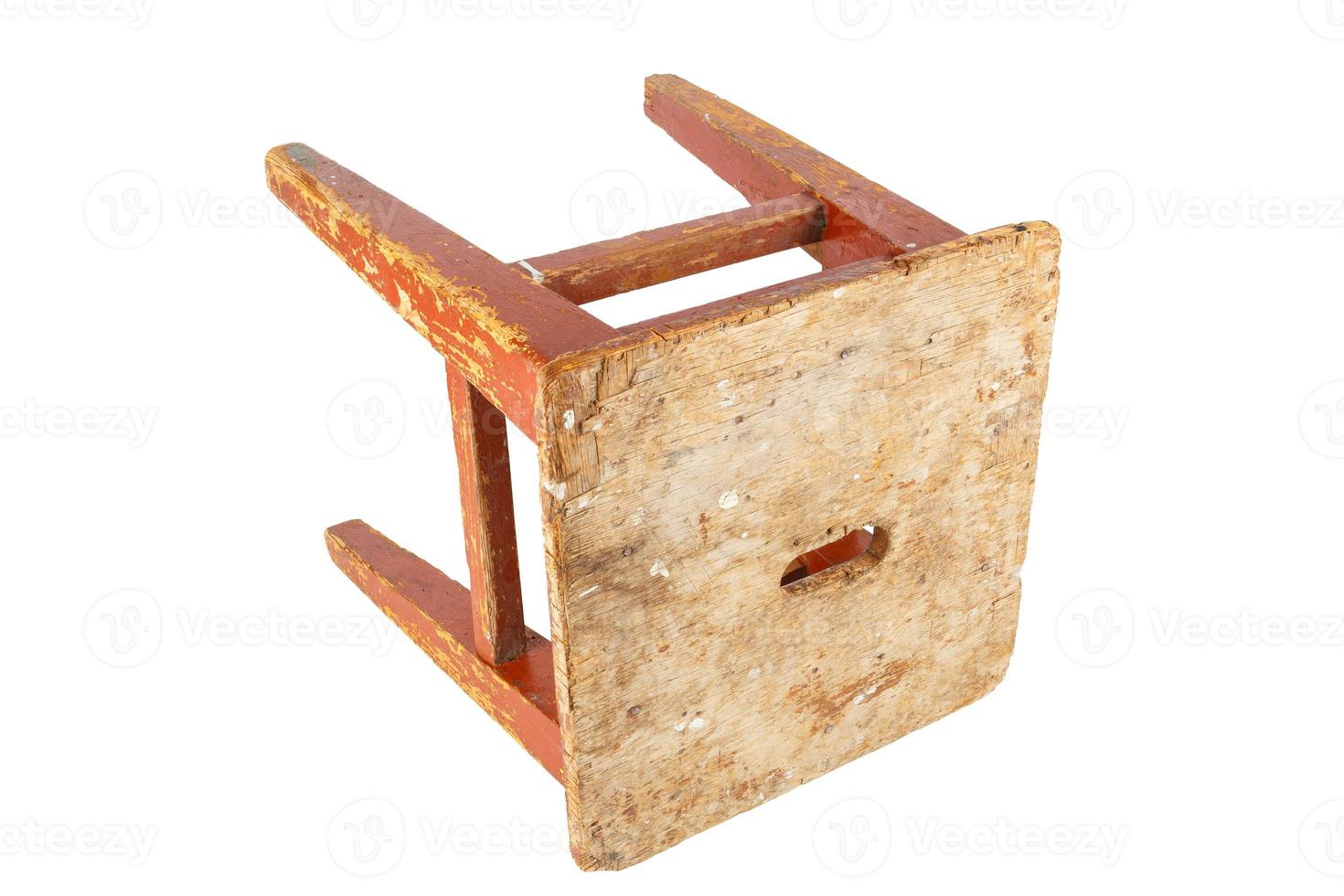 Old wooden stool with peeling brown paint. Loft style chair isolated on a white background. photo
