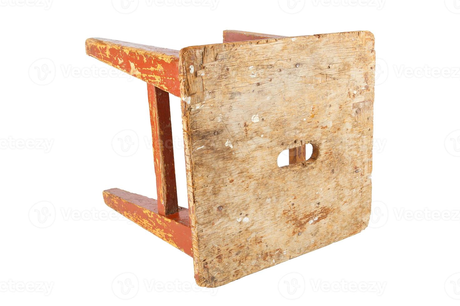 Old wooden stool with peeling brown paint. Loft style chair isolated on a white background. photo