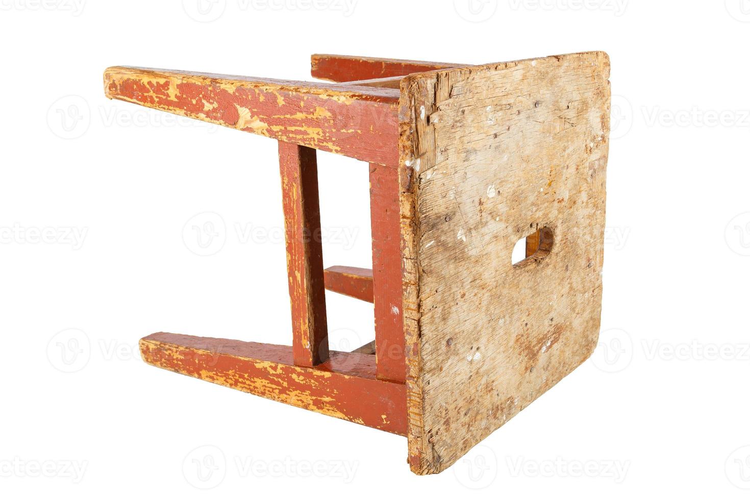 Old wooden stool with peeling brown paint. Loft style chair isolated on a white background. photo