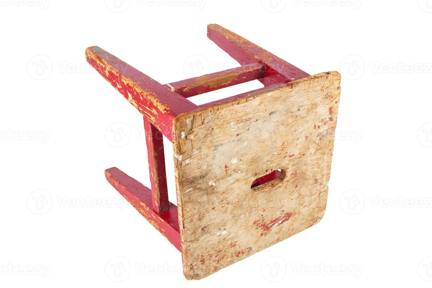 Old wooden stool with peeling red paint. Loft style chair isolated on a white background. photo