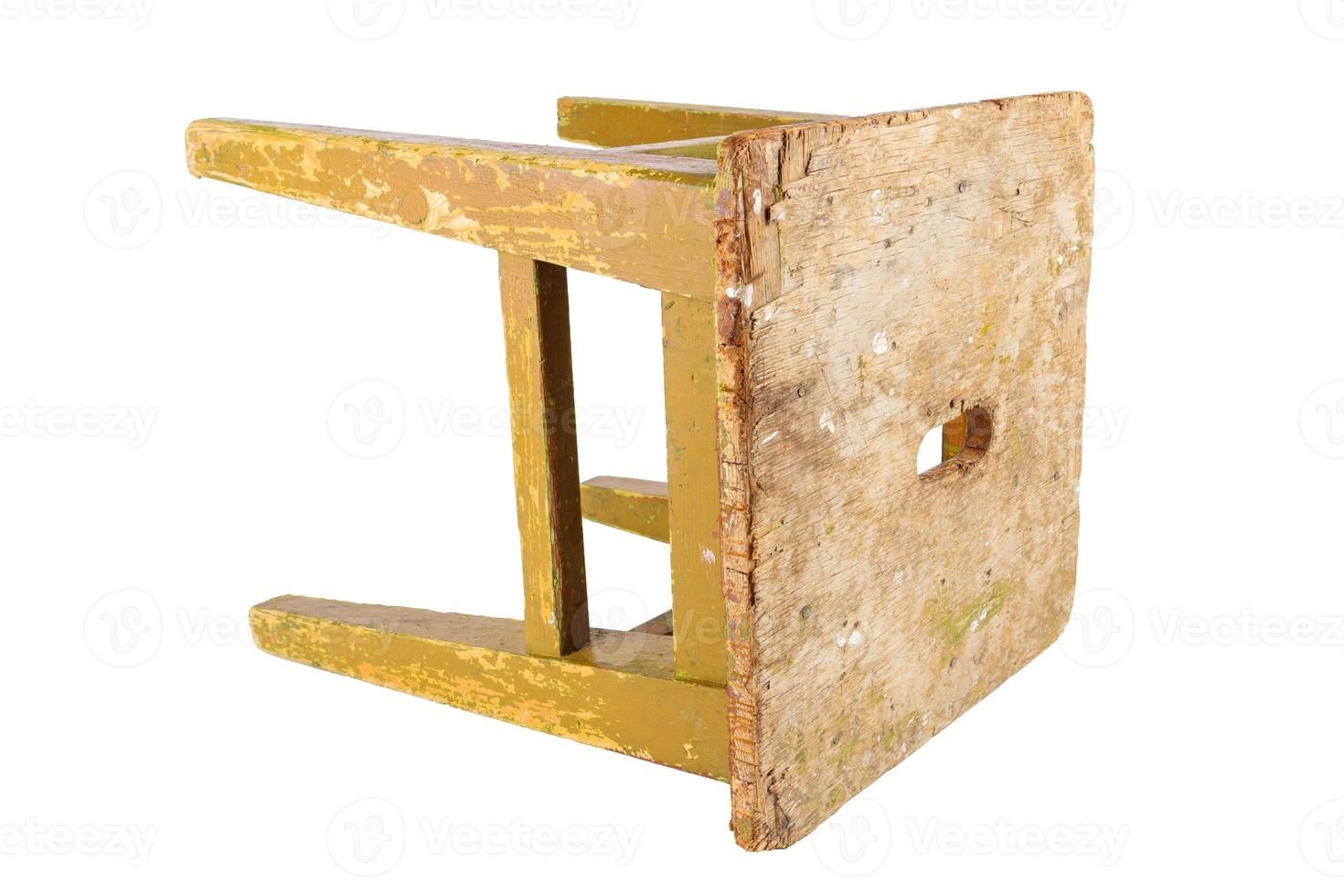 Old wooden stool with peeling ocher yellow paint. Loft style chair isolated on a white background. photo