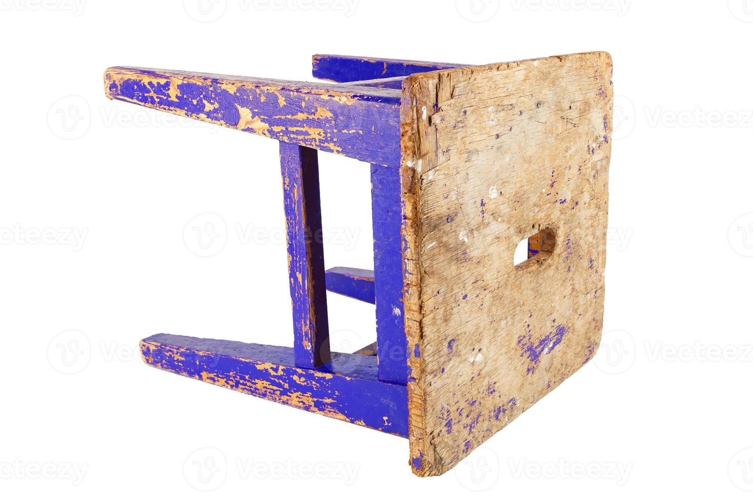 Old wooden stool with peeling blue paint. Loft style chair isolated on a white background. photo
