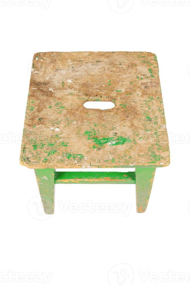 Old wooden stool with peeling lime green paint. Loft style chair isolated on a white background. photo