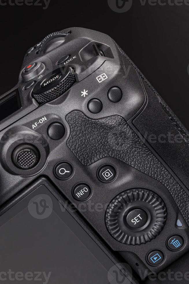 modern professional black digital photo camera controls - buttons, dials, wheels, screens and joystick - close-up macro view