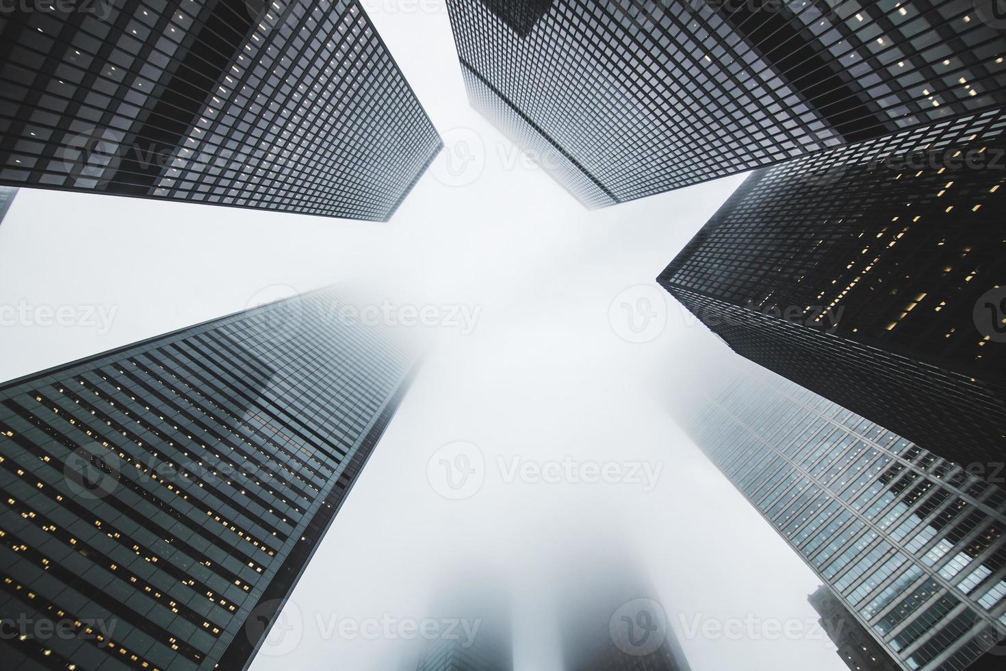 A low-angle shot of skyscrapers on a foggy day photo