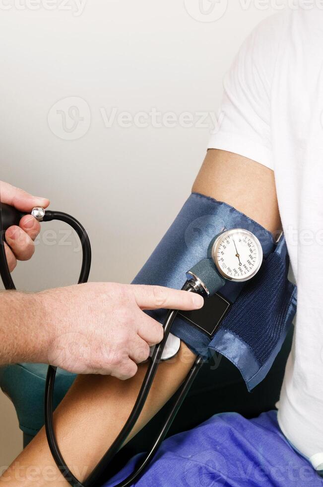 A clinician in the process of conducting a blood pressure examination photo