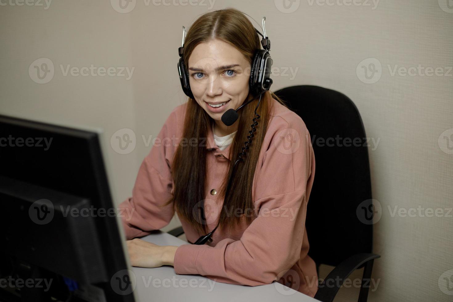 un feliz agente del centro de llamadas que trabaja en una línea directa de soporte en la oficina. el operador del centro de llamadas está hablando con el cliente. foto