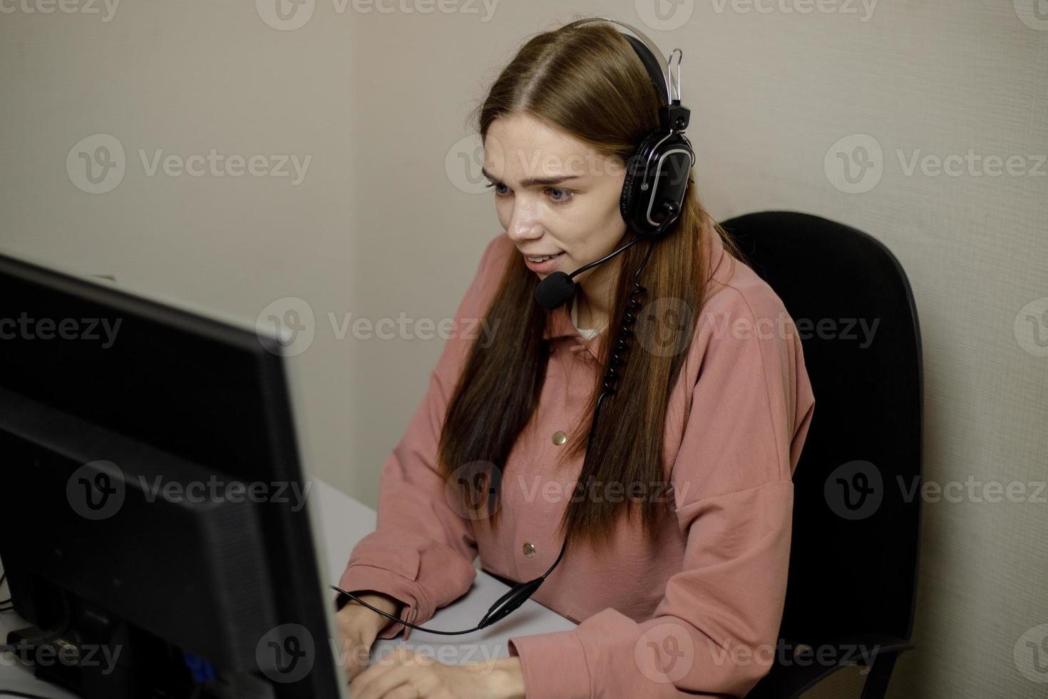 A happy call center agent working on a support hotline in the office. photo
