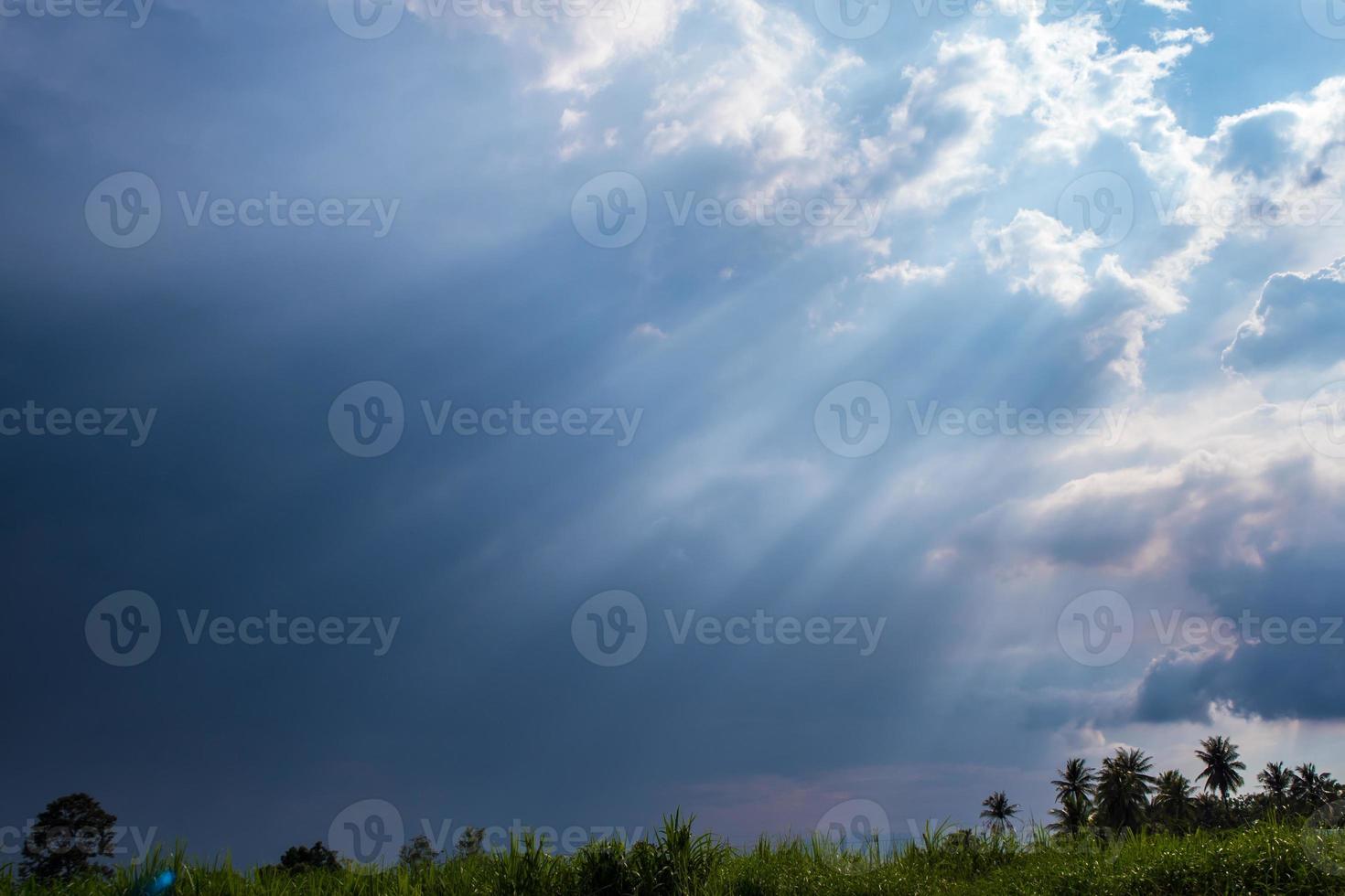 haz de luz solar detrás de nubes oscuras foto