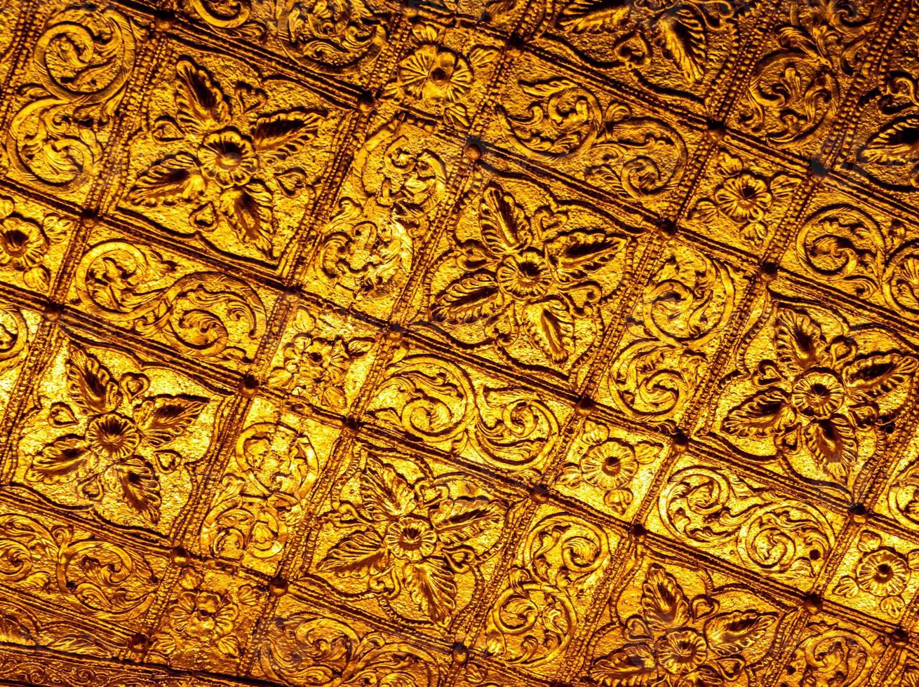Beautiful Burmese art pattern motifs decorative design on the golden walls of the rooms in the temple photo