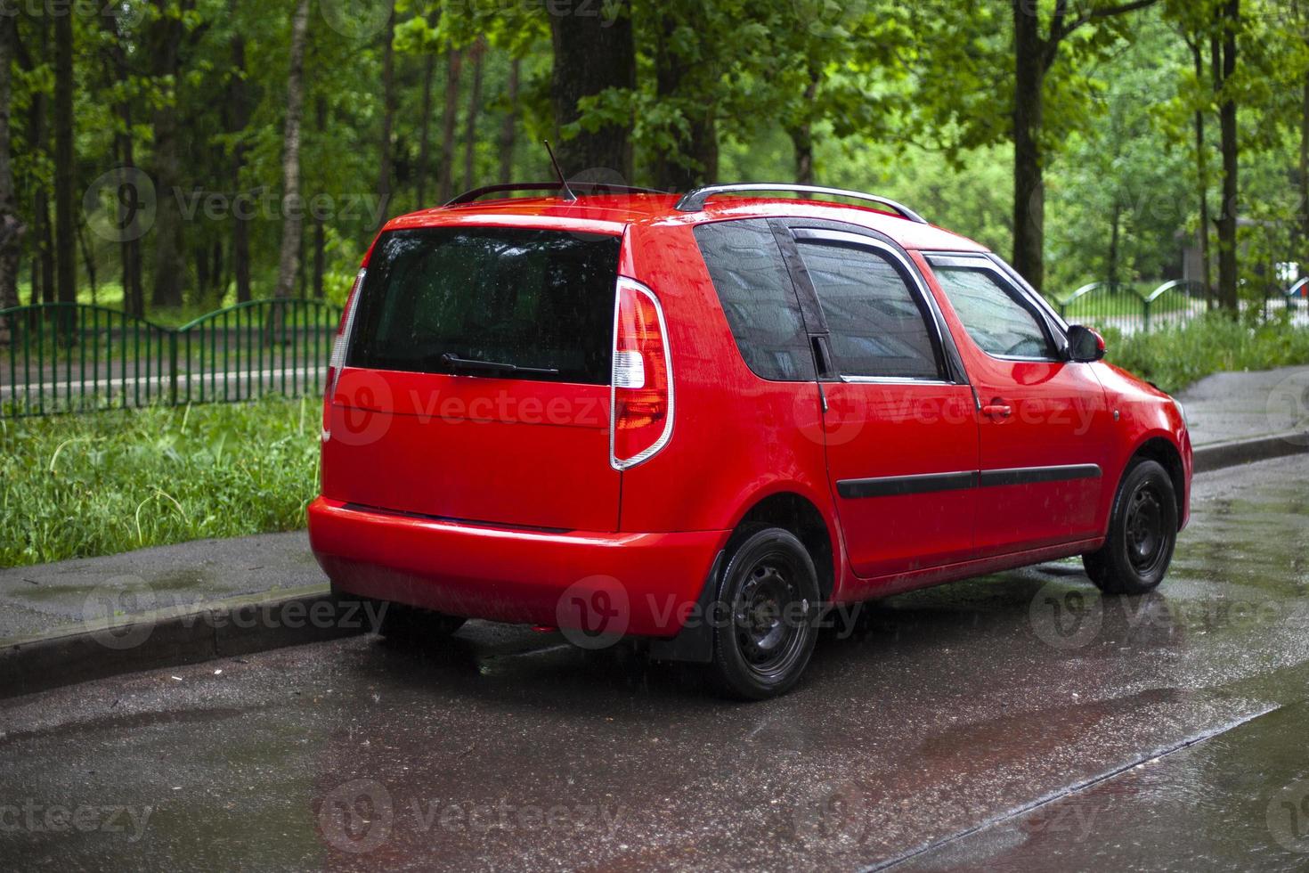 Red car in the parking lot. The car is on the road. photo