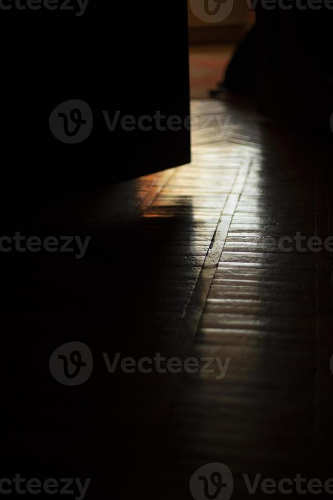 Light on parquet in room. Light from window in dark apartment. Reflection on floor. photo