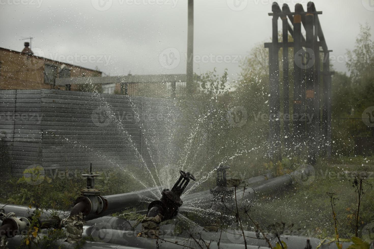 Pipe valve failure. Flow of boiling water. Steel pipe broke. Emergency. Pipeline accident. photo