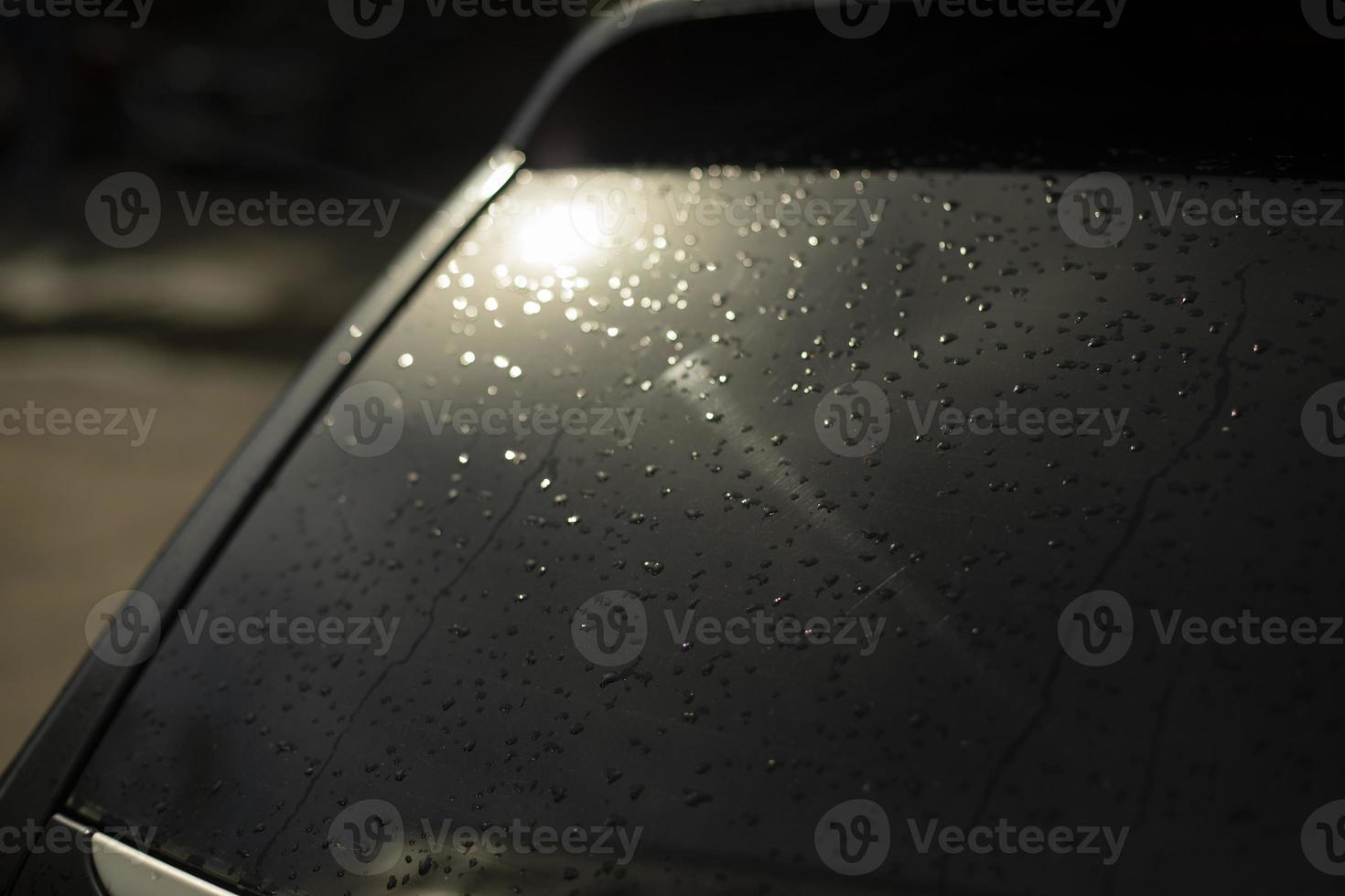 ventana trasera del coche negro. gotas en la ventana trasera del transporte. luz en la ventana del coche. foto