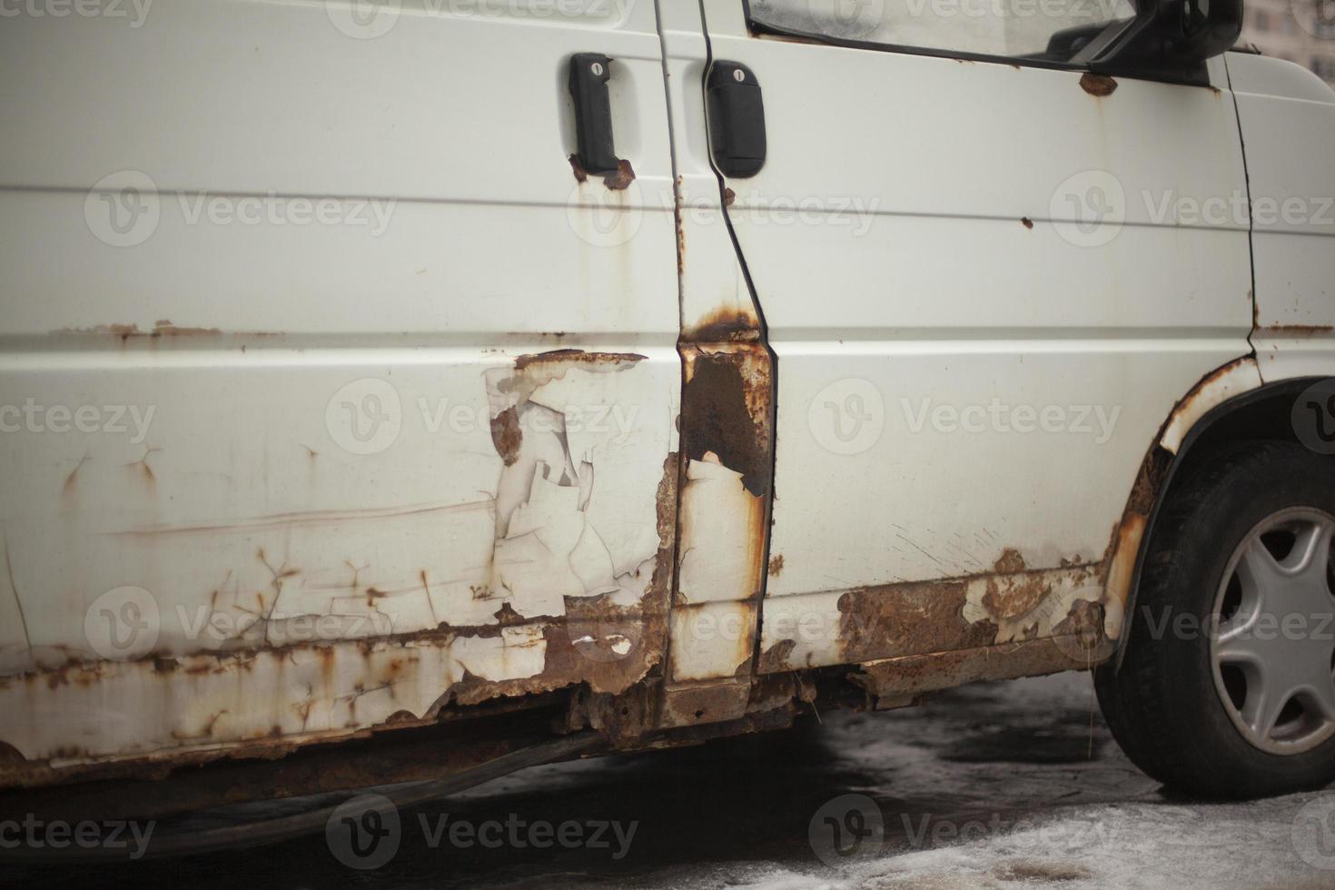 Rusty car bottom. Rust on surface of transport. Old white bus. photo
