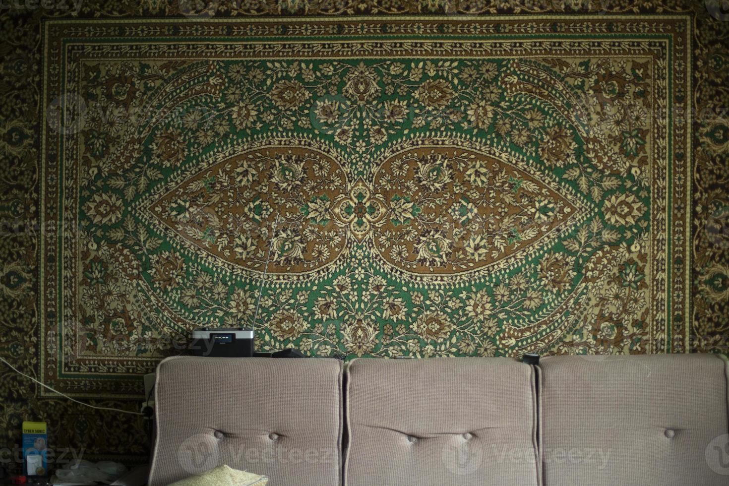 Carpet on wall. Fabric pattern. Old interior of dwelling. photo