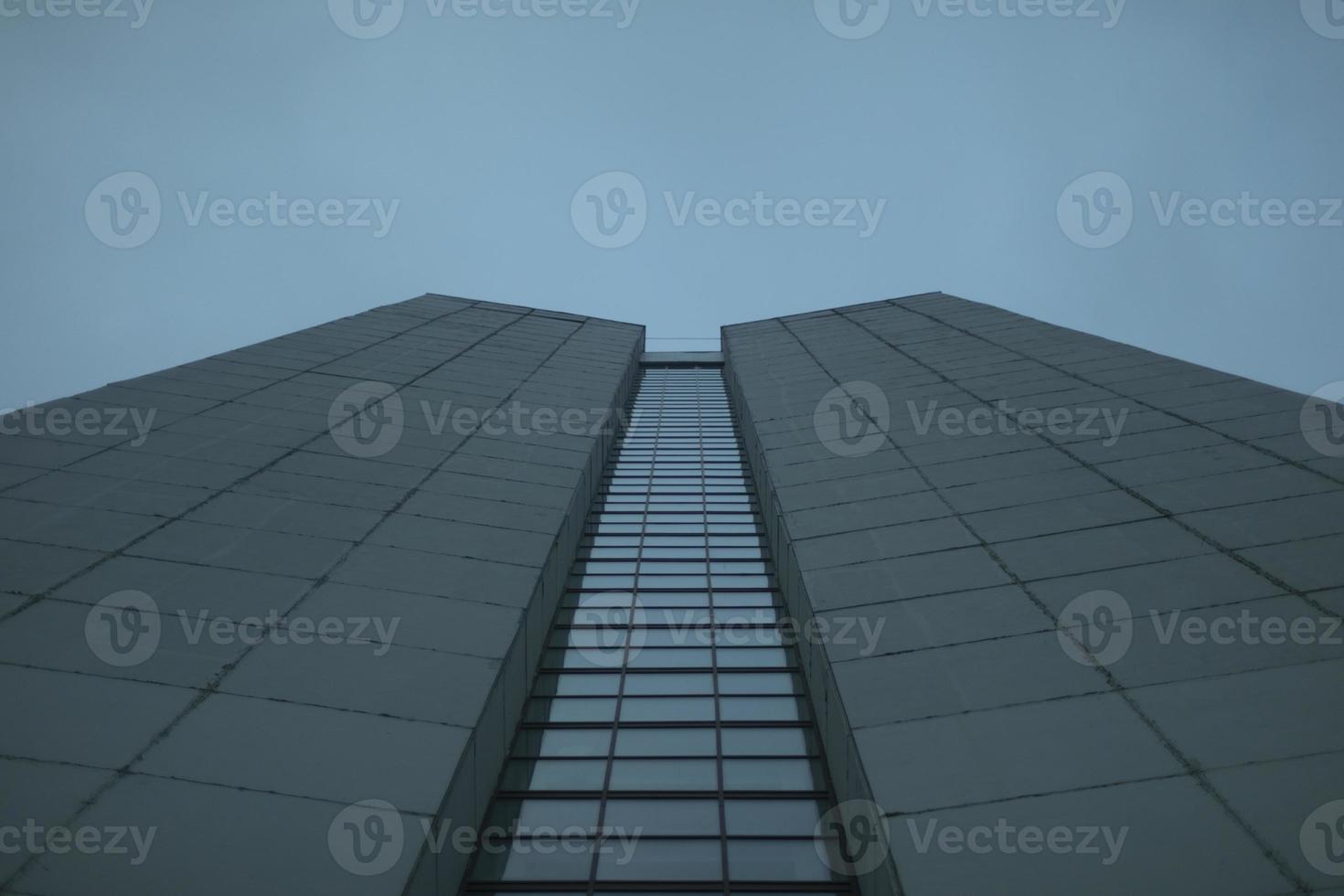 Windows in high-rise building. Details of modern architecture. Gray building and gray sky. photo