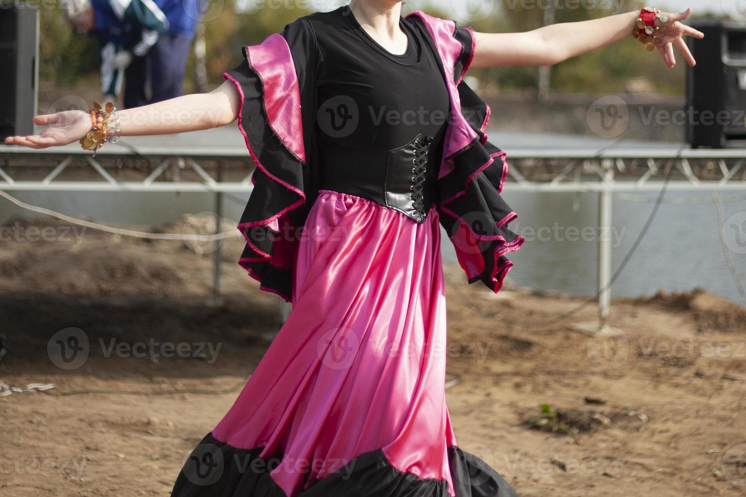 Gypsy dances in bright dresses. Girls dance on street Spanish dance. Bright fabric. photo