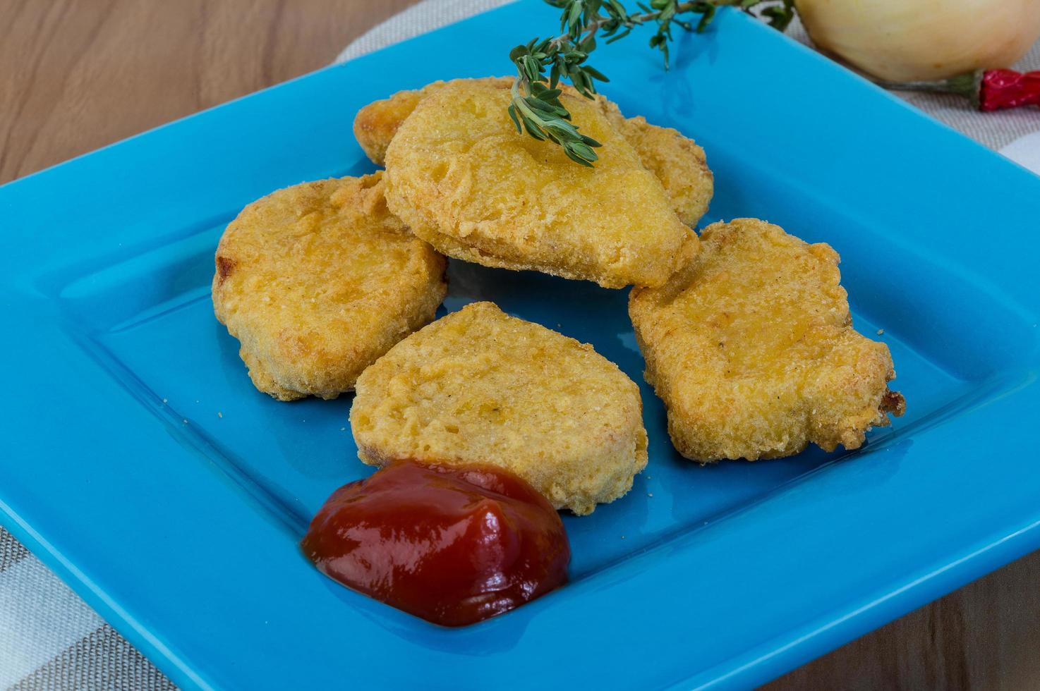 Nuggets on the plate and wooden background photo